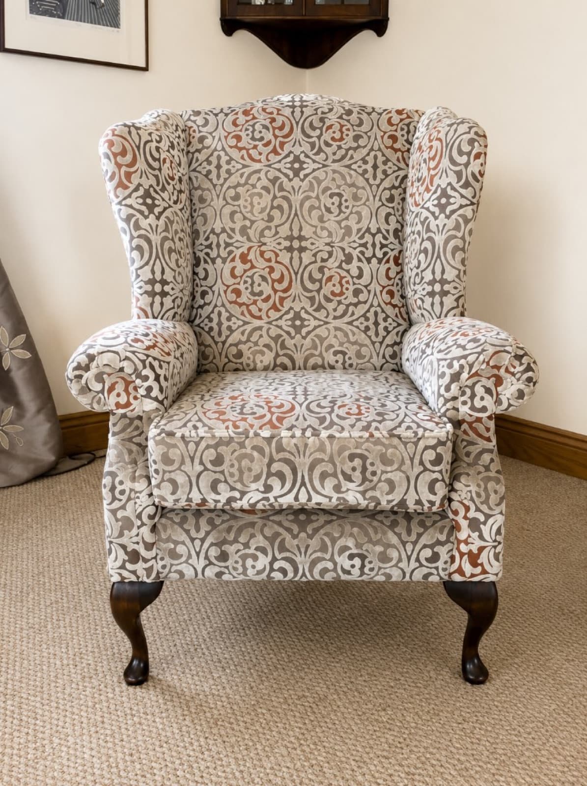 Same wingback armchair reupholstered in grey and terracotta medallion fabric