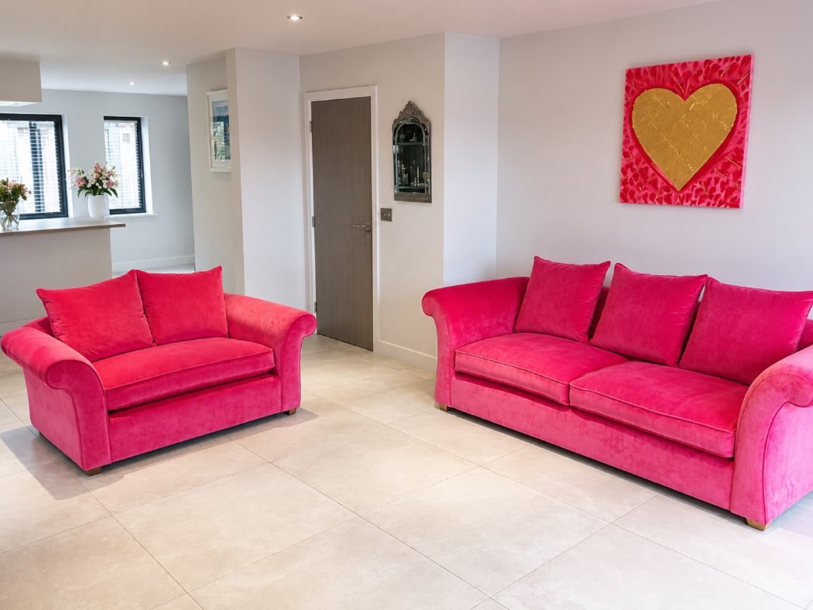 Pair of sofas reupholstered in vibrant fuchsia pink velvet