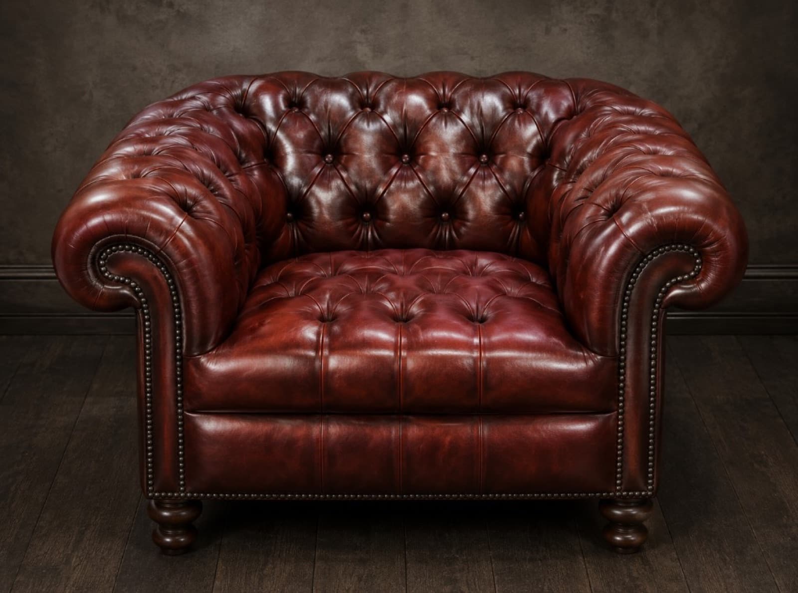 Deep oxblood leather Chesterfield armchair with button tufting and nailhead trim